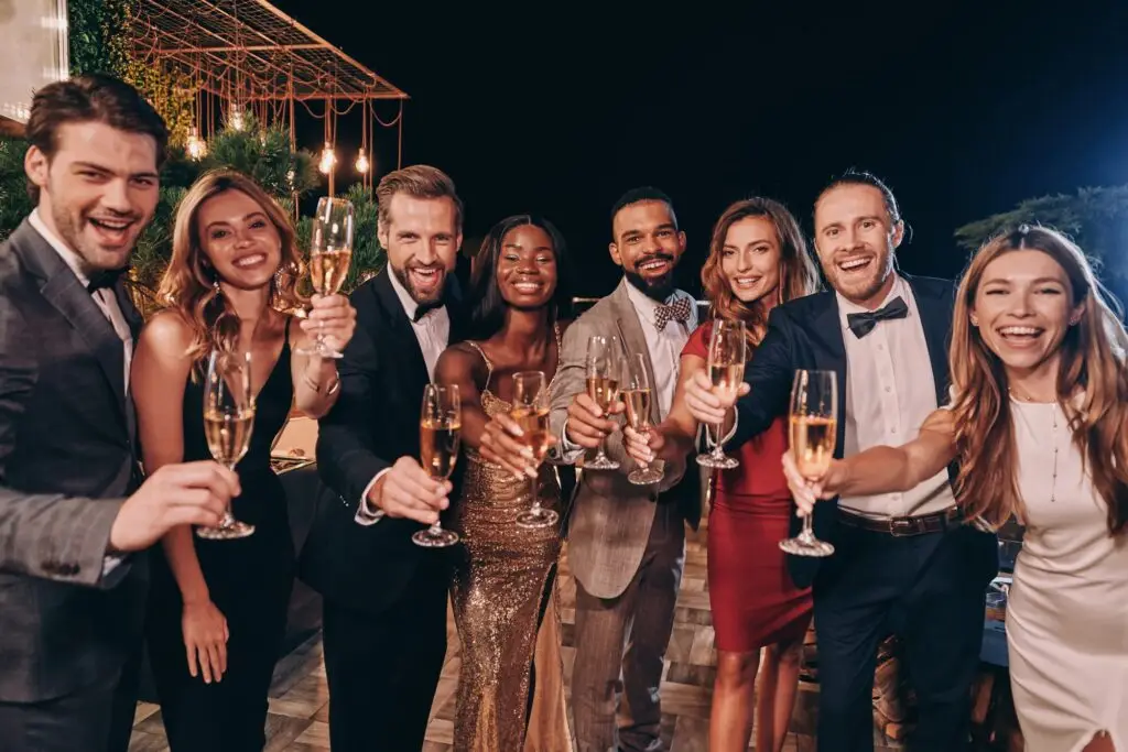 Group of people in formalwear toasting with champagne and smiling