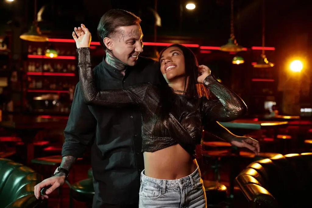 Multicultural couple enjoying a lively night out in the bar atmosphere